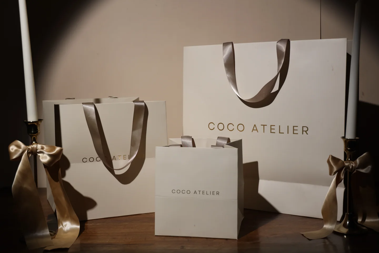 White Coco Atelier paper bags in two sizes with ribbon handles