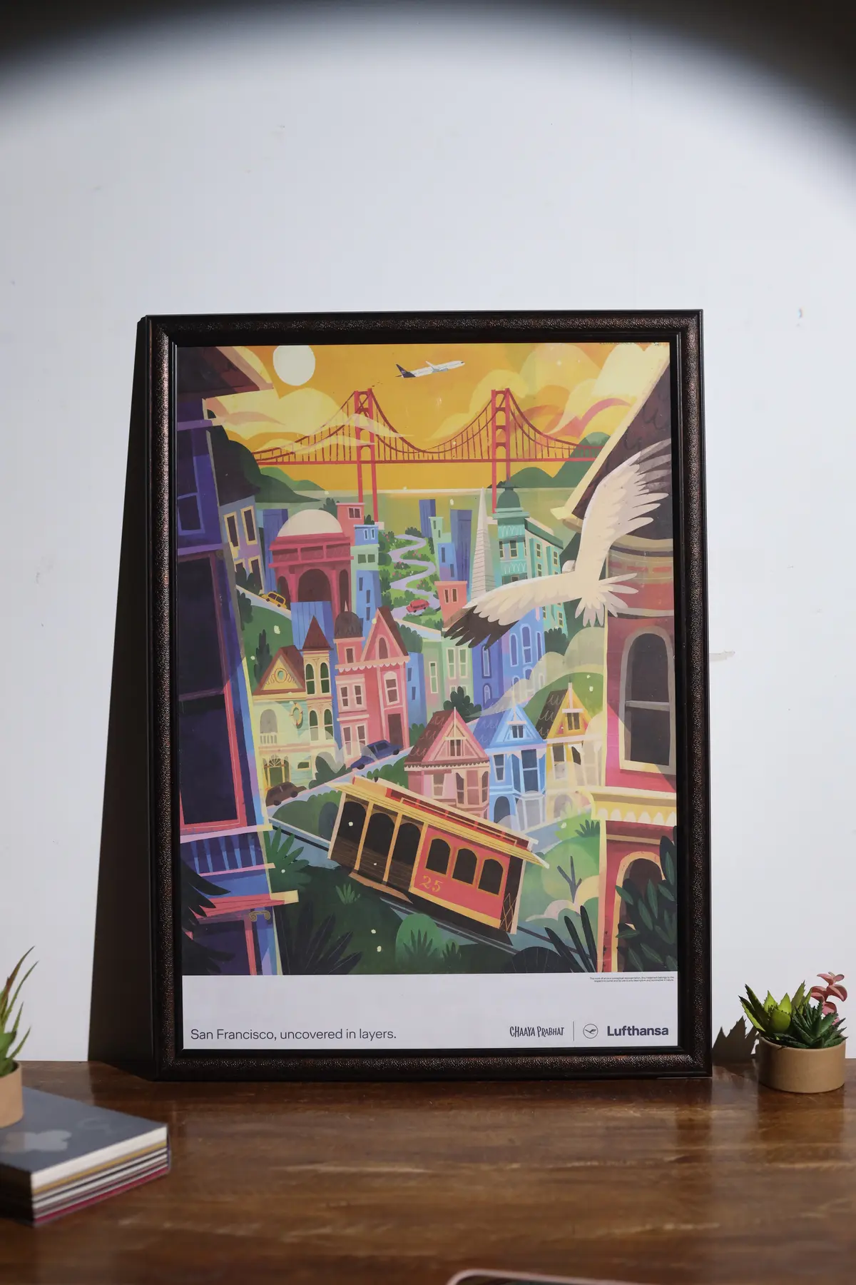 Colourful illustrated print displayed in a black frame