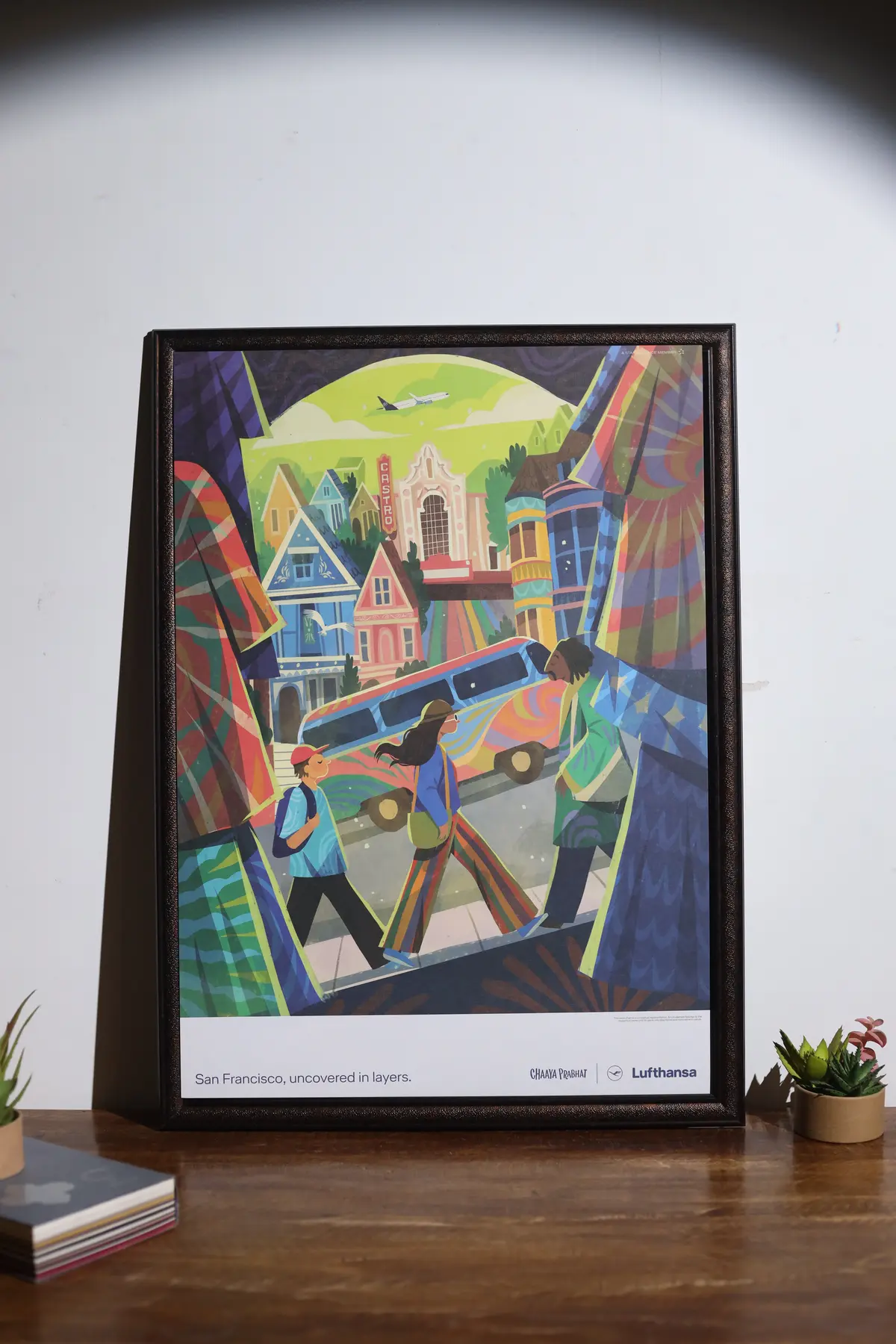 Brightly coloured illustrated print displayed in a black frame