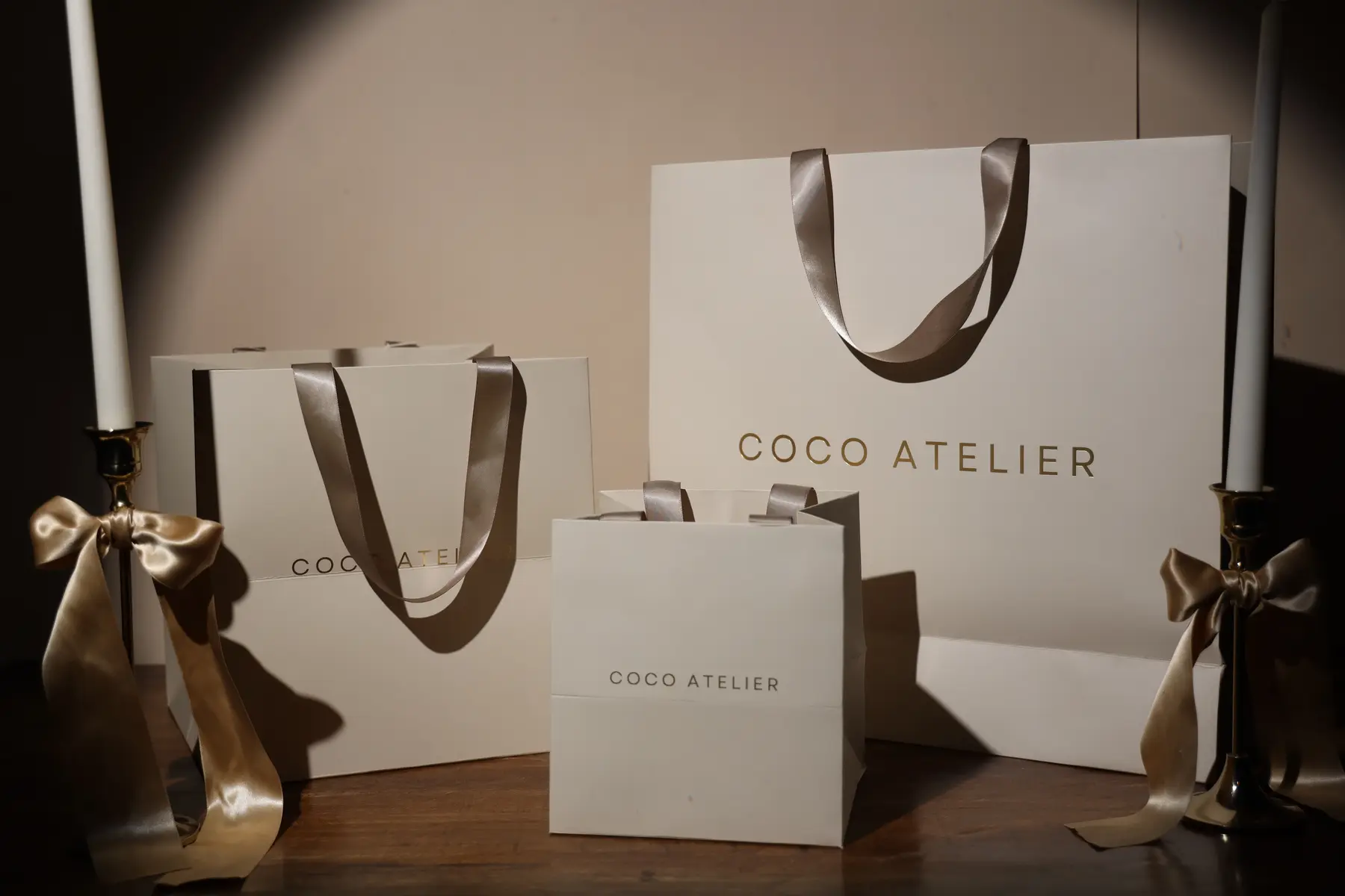 Collection of cream premium paper bags styled with ribbon details