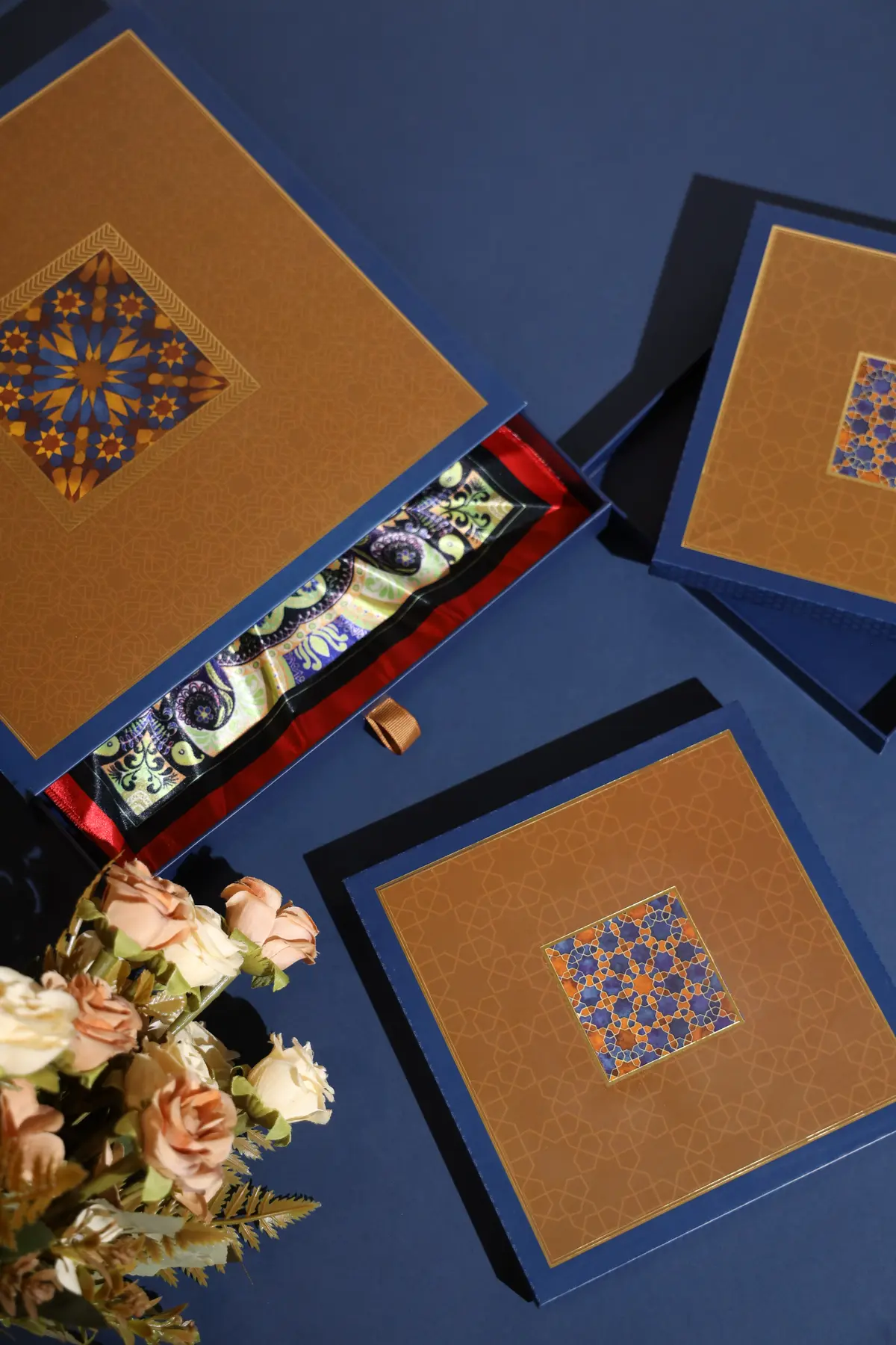 Blue and gold luxury rigid boxes arranged with floral styling