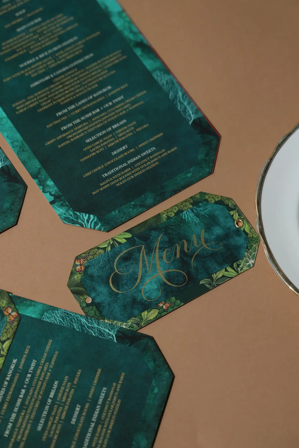 Deep green printed menu cards with gold typography and shaped tags